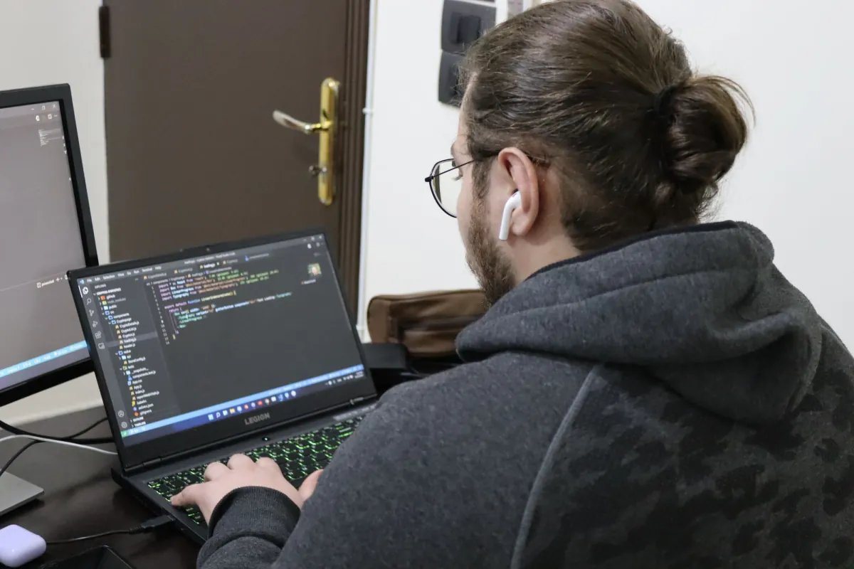 Mouaz at his laptop, seen from behind